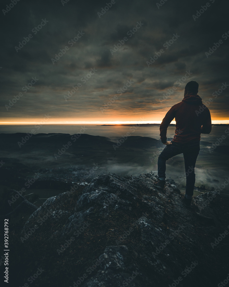 man on mountain top watching the sunset man on mountain top watching the sunset