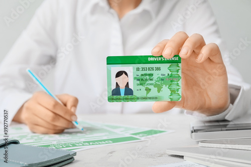 Woman with driving license and application form at table