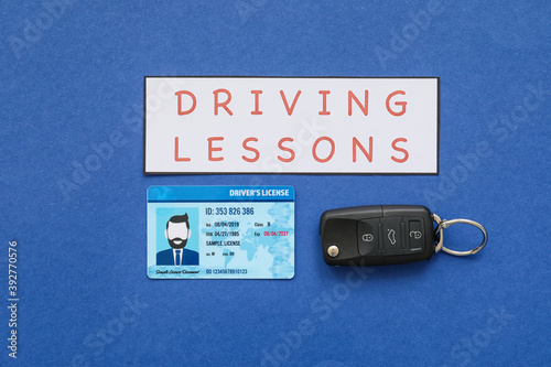 Driving license with car key on color background photo