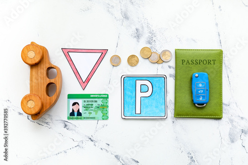 Driving license with car, key, passport and traffic signs on white background photo