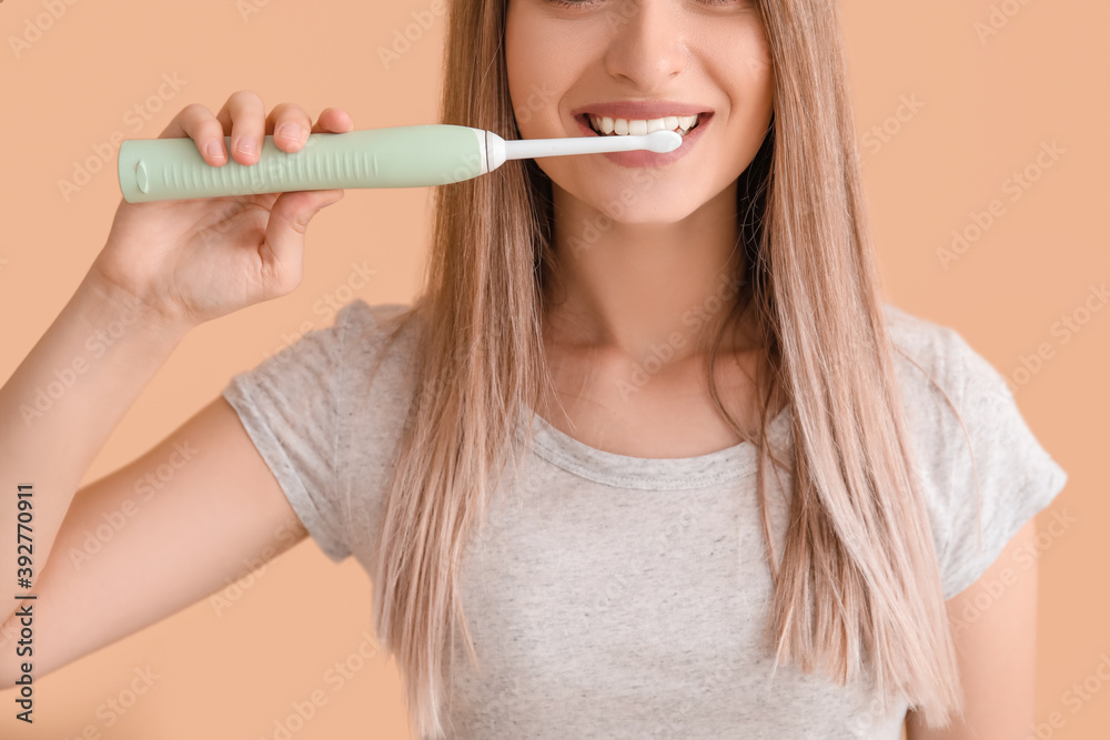Young woman with electric tooth brush on color background Young woman with electric tooth brush on color background