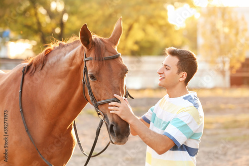 Young man with cute horse o...
