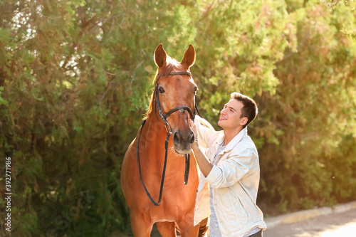 Young man with cute horse o...