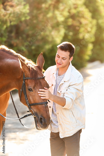 Young man with cute horse o...