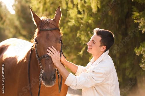 Young man with cute horse o...