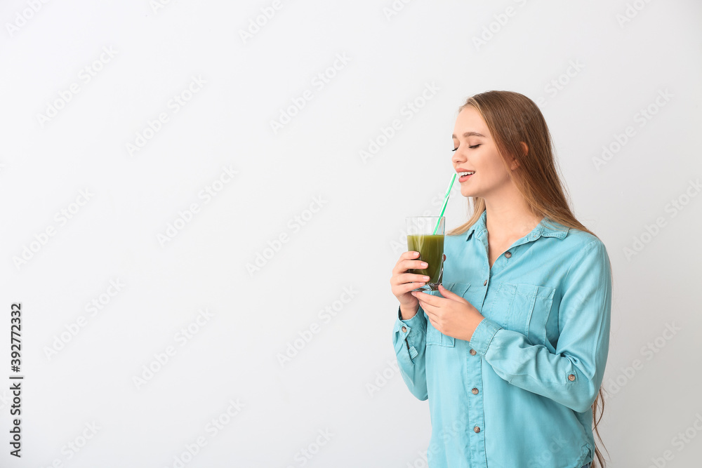 Young woman with wheatgrass juice on light background Young woman with wheatgrass juice on light background