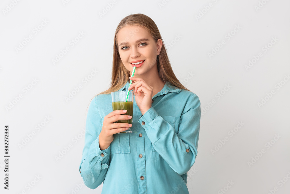 Young woman with wheatgrass juice on light background Young woman with wheatgrass juice on light background