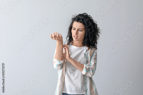 Allergic young woman scratc...