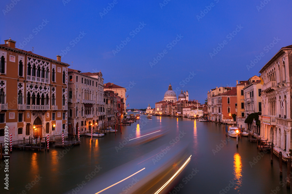 Long exposure of a boat traveling down the Grand Canal in Venice, Italy at twilight