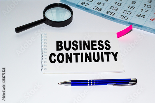 business continuity. diary book, Magnifying glass, pen , pencil, table. Could be for business, financial and marketing concepts