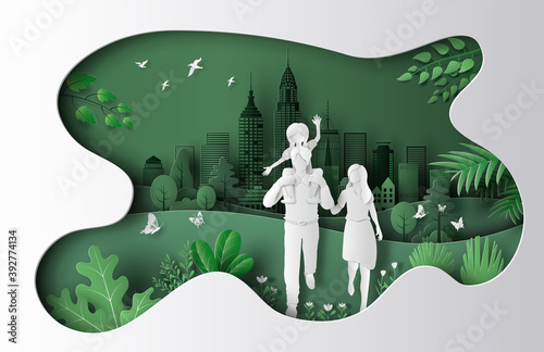 Fototapeta Naklejka Na Ścianę i Meble -  A family enjoy fresh air in the park with a city background, save the planet and energy concept, paper art, and craft style.