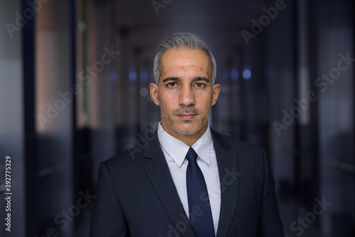 Portrait of handsome businessman wearing suit and looking at camera