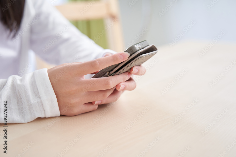 リビングでスマホを見る日本人の女の子の手元 リビングでスマホを見る日本人の女の子の手元