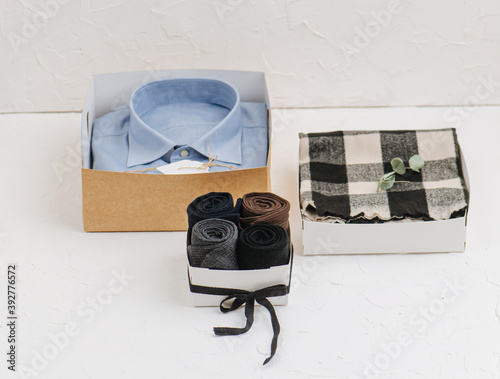 Dress shirt, blanket and rolled socks, all in box bases, placed as a gift photo