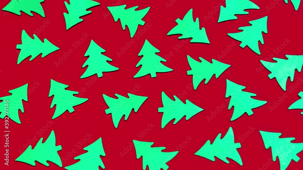 Lots of green Christmas trees are flashing on trendy red background. Shiny decorative elements pattern. Felling of trees. Stop motion animation. Bright new year's concept. Xmas symbol. Environment. Lots of green Christmas trees are flashing on trendy red background. Shiny decorative elements pattern. Felling of trees. Stop motion animation. Bright new year's concept. Xmas symbol. Environment.
