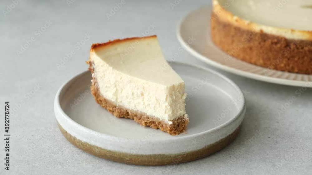 Taking bite of cheesecake. Plain classical new york cheesecake slice, eating with fork Taking bite of cheesecake. Plain classical new york cheesecake slice, eating with fork