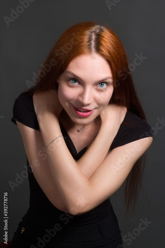 portrait of a beautiful red haired young positive woman in studio