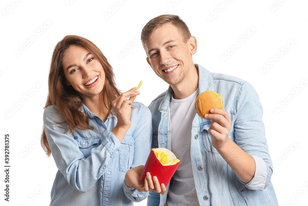 Young couple with french fries and burger on white background Young couple with french fries and burger on white background