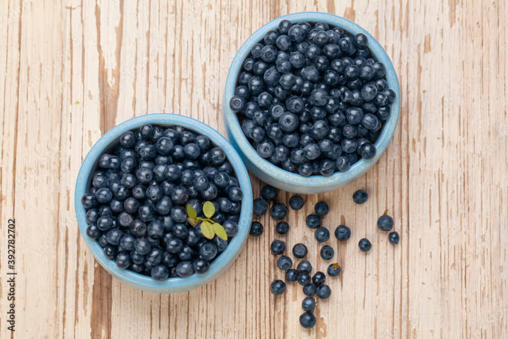 Blueberries in blue bowls on white wooden board background, top view. Healthy eating Blueberries in blue bowls on white wooden board background, top view. Healthy eating