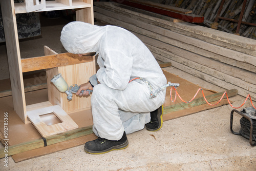 man painting with paint gun furniture, child's kitchen, homemade