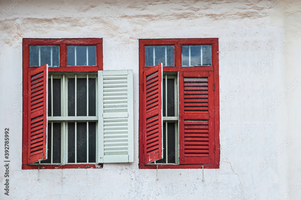 Old red window on white concrete wall