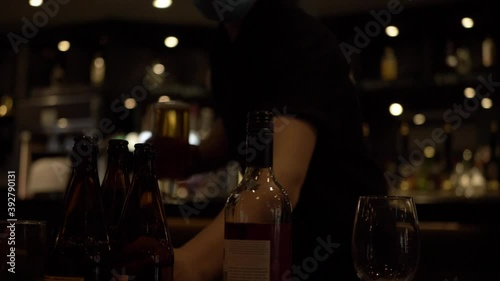 Waiter serving drinks and bottles in a bar medium panning shot photo