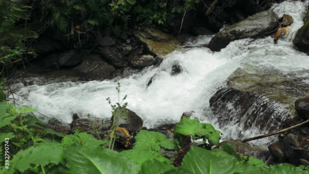 Pan left camera movement showing a mountain river and a small waterfall in the Fagaras Carpathian Mountains