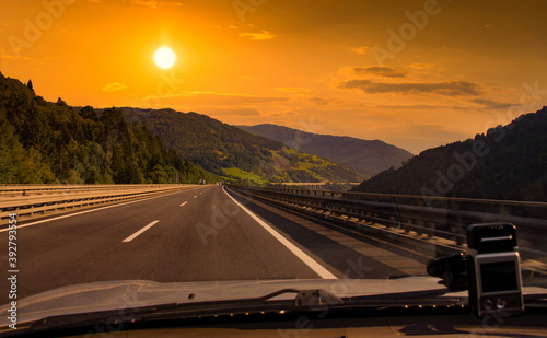 Road trip. View from car on the asphalt road in mountain.  Sunset time. © Sergey Fedoskin