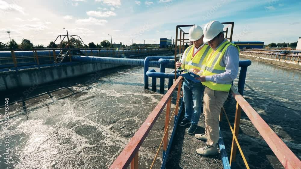 Workers of a sewage cleaning site are analyzing a water probe
