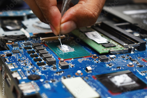 applying and replacing thermal paste on laptop processor using fingers and tube