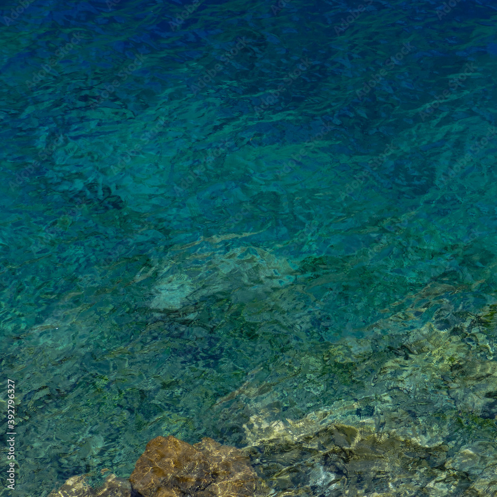 Abstract image of quiet ripples in the pure water of translucent turquoise mountain lake in Marguzor, Tajikistan