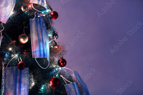 Christmas tree decorated with surgical masks - illustration to virus pandemic 2020 / 2021 social distance, lockdown and quarantine isolation. photo