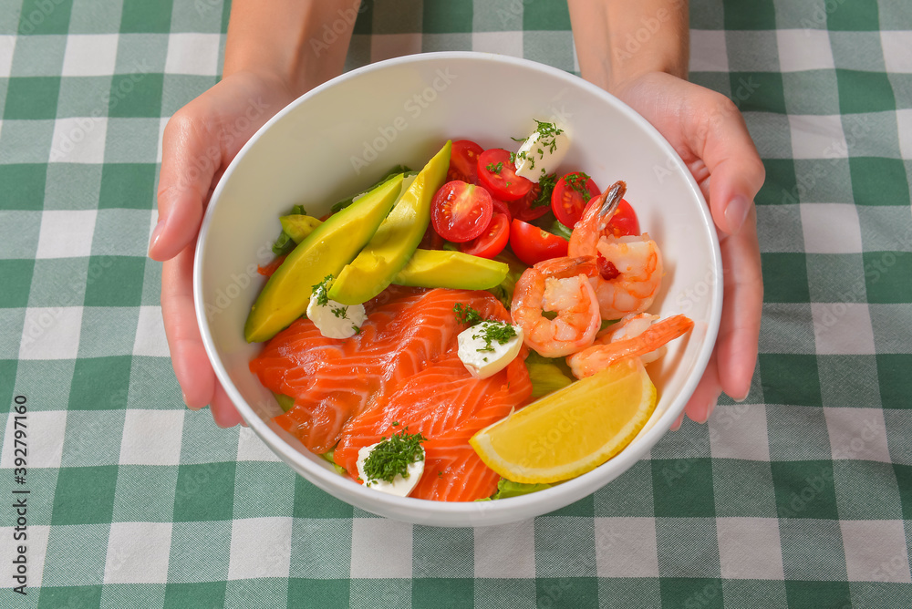 Fresh salad with seafoods, tomato and herbs. Red salmon, small shrimps, avocado, cherry tomatoes.