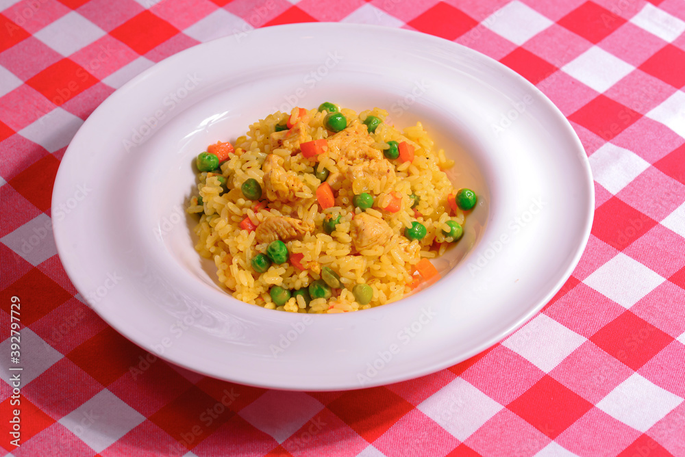 Plain vegetable rice and healthy green vegetables served in a white plate over red plaid background tablecloth. Plain vegetable rice and healthy green vegetables served in a white plate over red plaid background tablecloth.