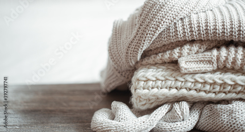 A stack of warm knitted items on blurred white background copy space. photo