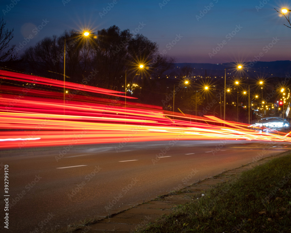 Red traffic lights shot at long exposure going downhill.