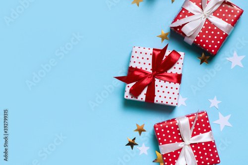 Red christmas gift box with confetti on blue background