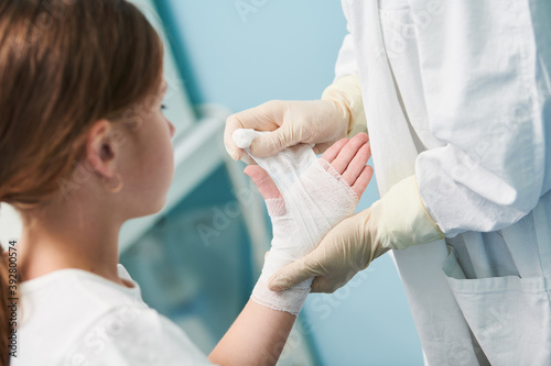Billede på lærred surgeon doctor bandaging child's hand in clinic