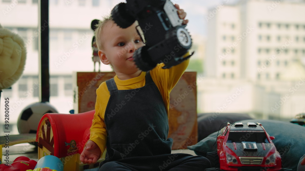 Portrait of toddler boy playing toy car indoors. Nice kid having fun at home. Portrait of toddler boy playing toy car indoors. Nice kid having fun at home.