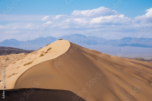 Sand dunes with clouds backgorund. Natural landscape. Altyn-Emel singing dunes or barkhan. Altyn-emel national park in Kazakhstan. Tourism travel in Kazakhstan concept.