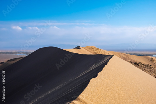Sand dunes with clouds backgorund. Natural landscape. Altyn-Emel singing dunes or barkhan. Altyn-emel national park in Kazakhstan. Tourism travel in Kazakhstan concept.