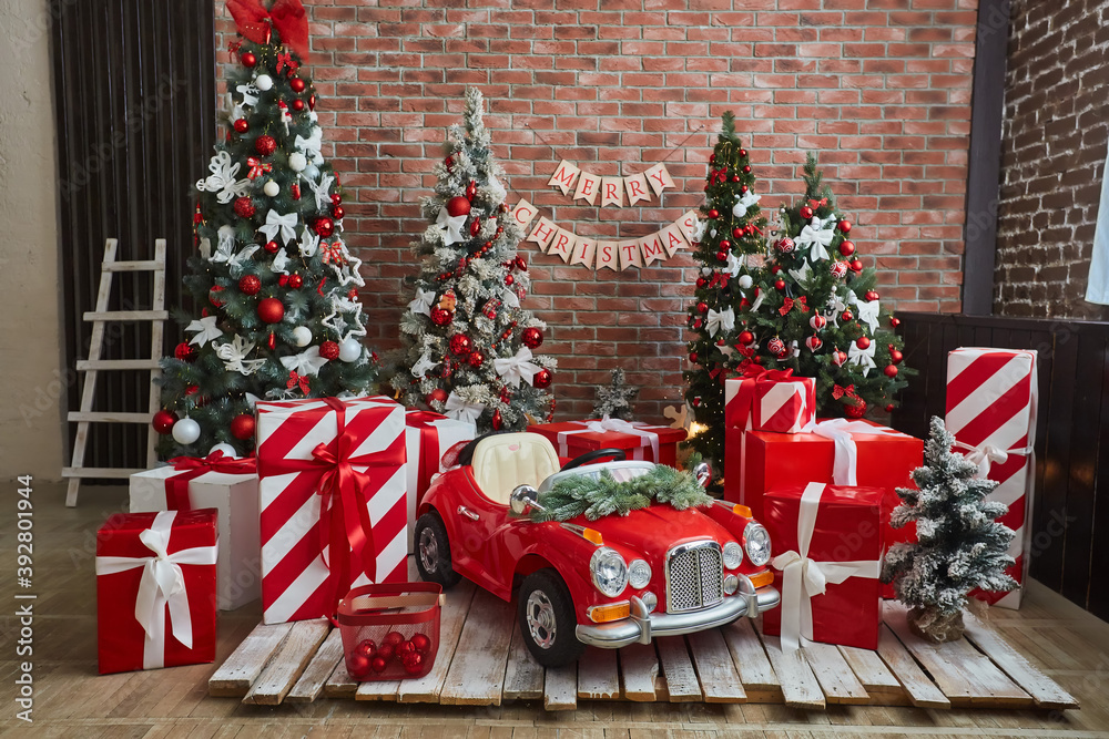 The room or photo zone is decorated for Christmas or New year. Interior of  the room with a Christmas tree and a children's car, decorations for the  holiday. Stock Photo | Adobe