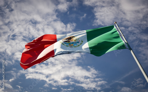 Mexico national flag waving at sky background close-up.
