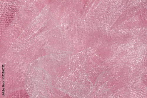 Pink tulle fabric texture top view. Coral background. Fashion color trends feminine tutu skirt flat lay, female blog backdrop for text signs desidgn. Girly abstract wallpaper, textile surface. photo