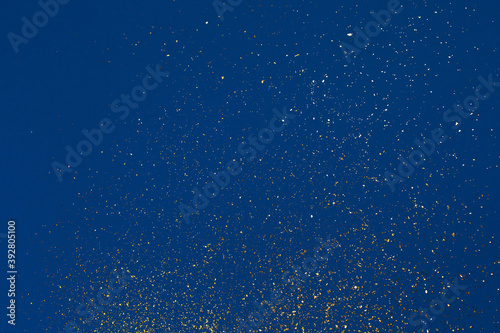 Gold glitter on blue background. Holiday abstract texture