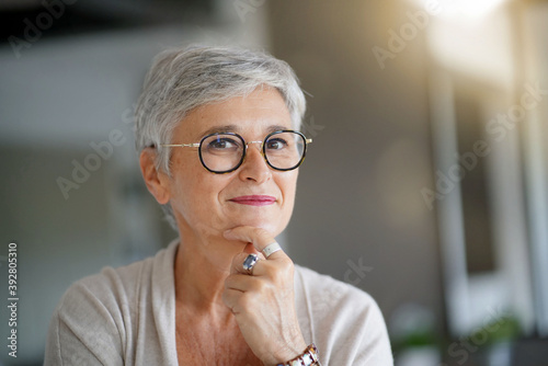 Foto Portrait of a attractive smiling 55-year-old woman with white hair