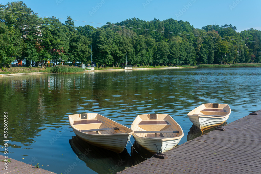 Obraz premium Three docks near the pier for walks on the lake, boat rental. Selective focus