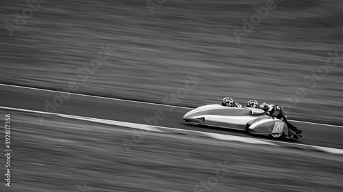 Foto A panning shot of a racing sidecar as it corners on a track.