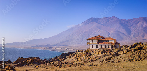 Landscape along the Pacific coast of Chile with a dilapidated house in the ghost-town of Gatico