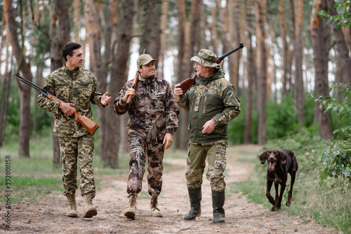 Fotografie Hunting Season Happy Men with Rifles and Gun Dog.